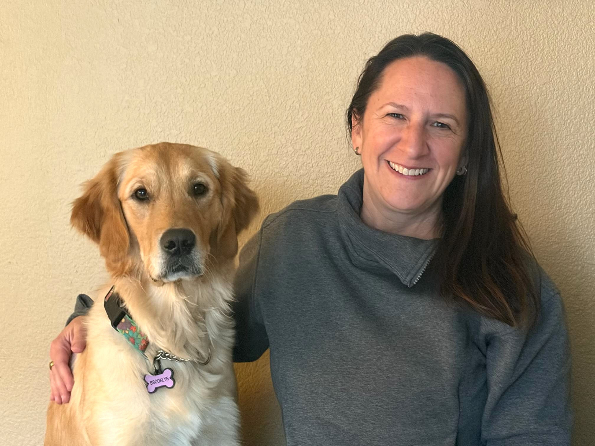 Chelsey Sicheneder smiling next to a yellow lab for her JLAD Board photo